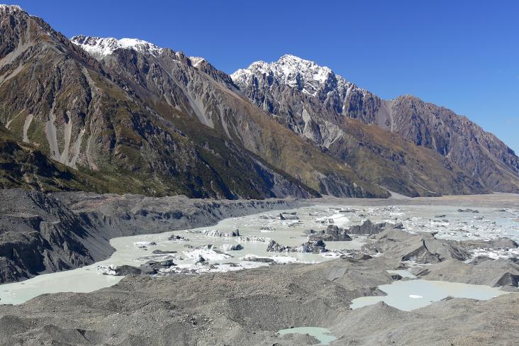 Tasman Glacier covered with rock debris, Tasman Lake with icebergs and Tasman Valley. Liebig Range beyond. Aoraki/Mount Cook National Park, MacKenzie Dist., NZ.