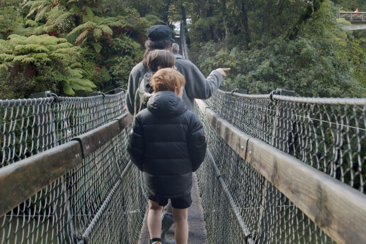 Family cross a swing bridge
