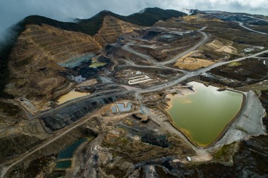 open cast coal mine with dug-out hillsides, roads, and pooling water