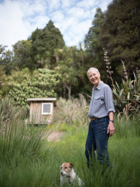 Ann Graeme with her cute terrier in a grassy outdoor area
