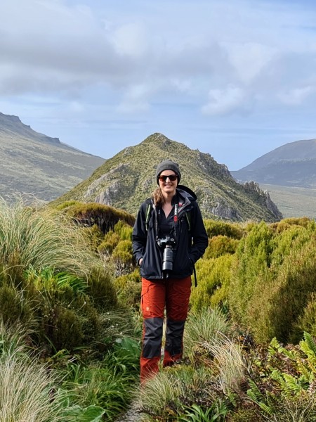 Hannah Shand with her camera on the top of a hill on Campbell Island