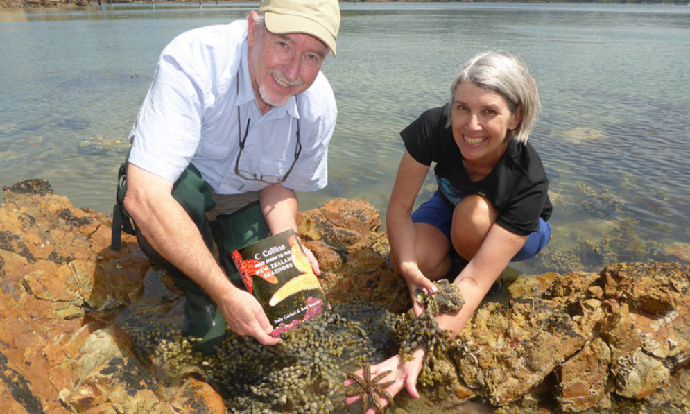 Sally Carson and Rod Morris in a tide pool with their new book