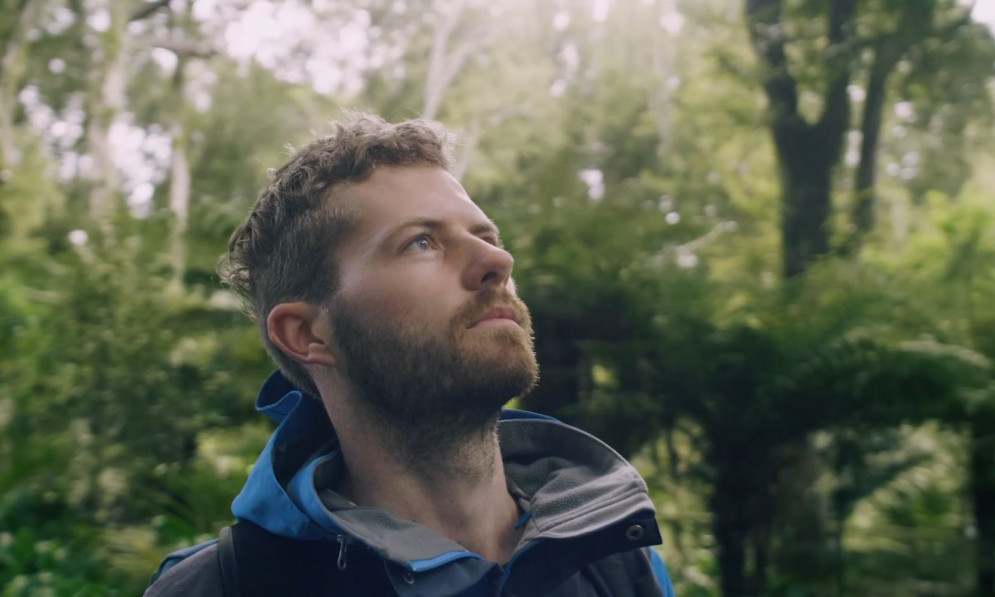 Man in the forest looks up in contemplation 