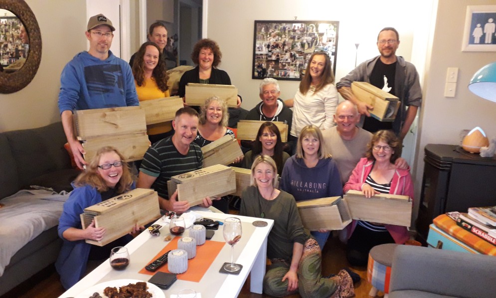 16 Pest free Hibiscus Coast volunteers holding traps in someone's lounge