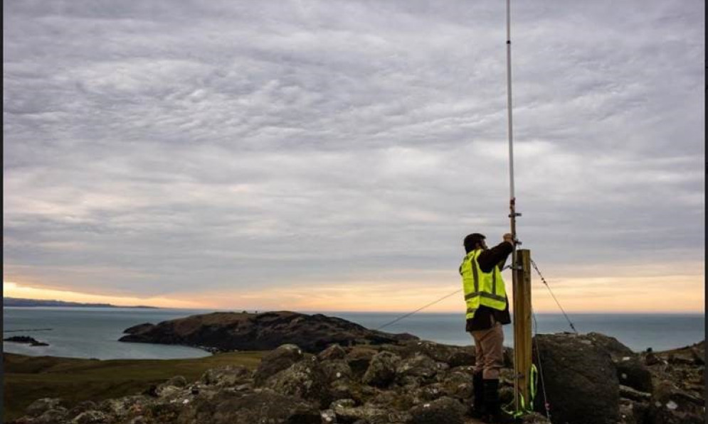 Someone installing an antenna in Otago in sunset