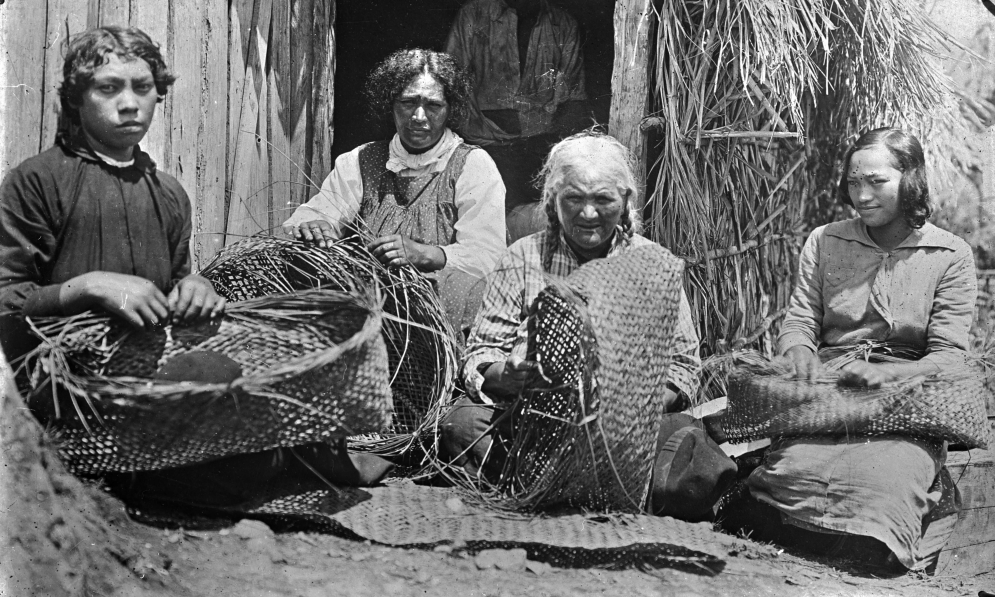 Group of Māori women weaving kete flax baskets at Rangiahua 1918. Godber Collection Alexander Turnbull LibraryWikimedia