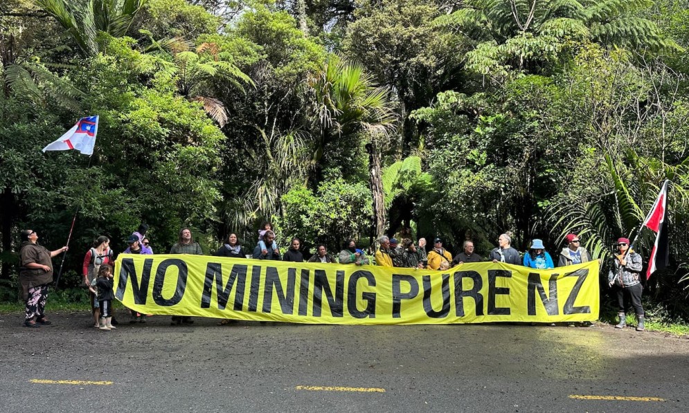 Forest & Bird members holding "No Mining Pure NZ" banner near kauri forest near Kerikeri
