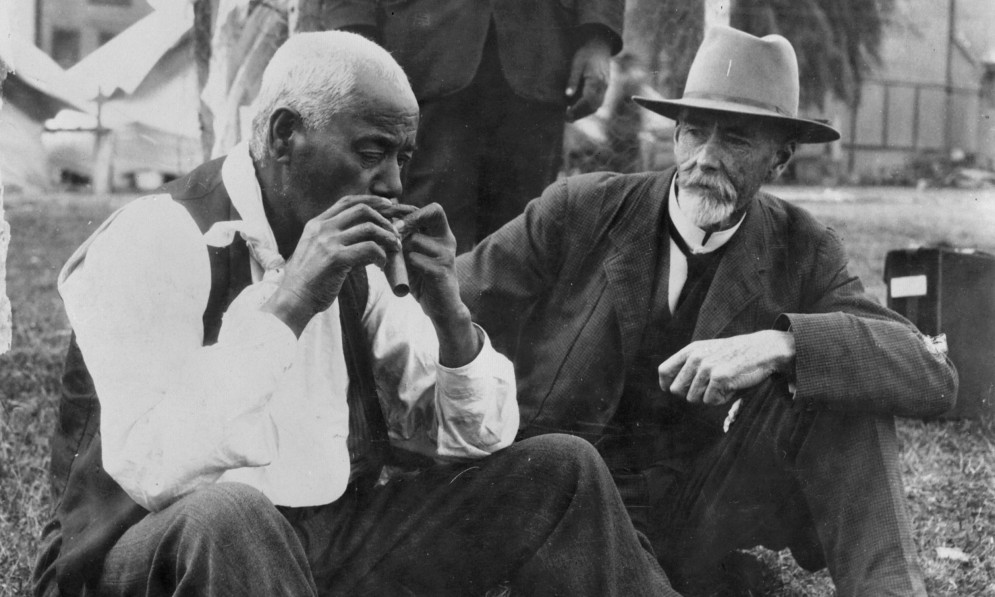 Ethnologist Elsdon Best watches Tairāwhiti Gisborne man Aporo playing a nose flute in 1923. Image Alexander Turnbull Library 