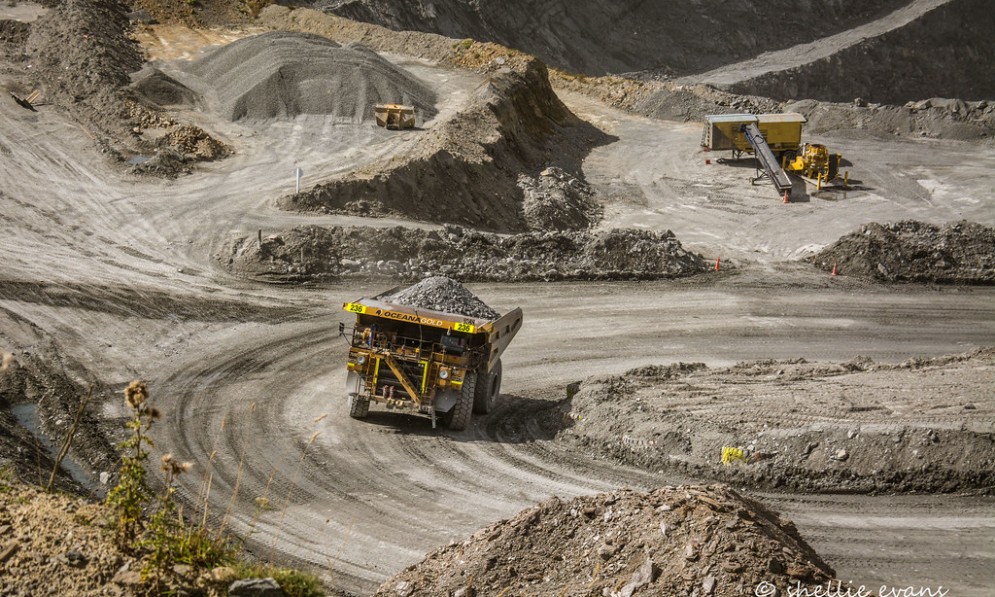 Diggers and trucks carrying coal in an OceanaGold mining project