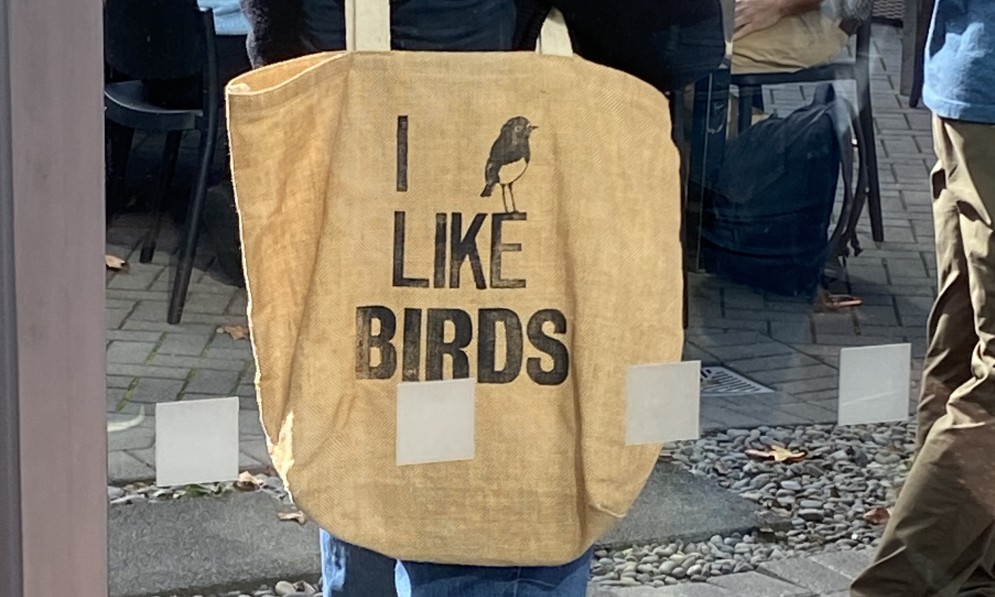 Woman with a cloth bag that says I Like Birds
