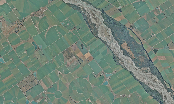 a braided river weaves through dense farmland