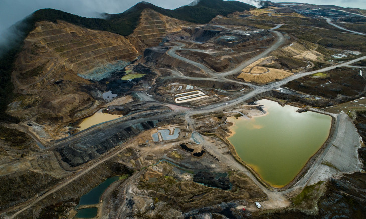 open cast coal mine with dug-out hillsides, roads, and pooling water