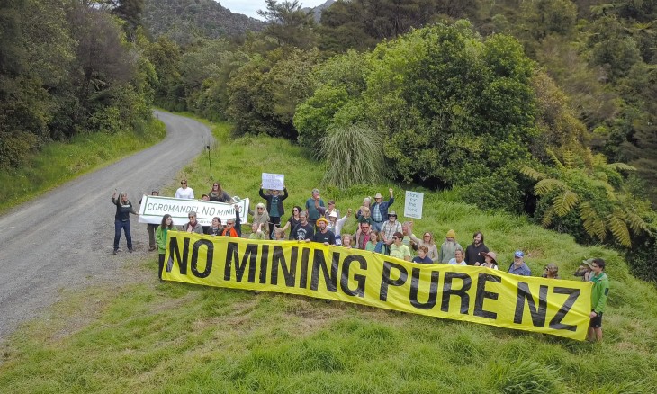 Crowd holding a "No mining pure NZ" banner in the Coromandel