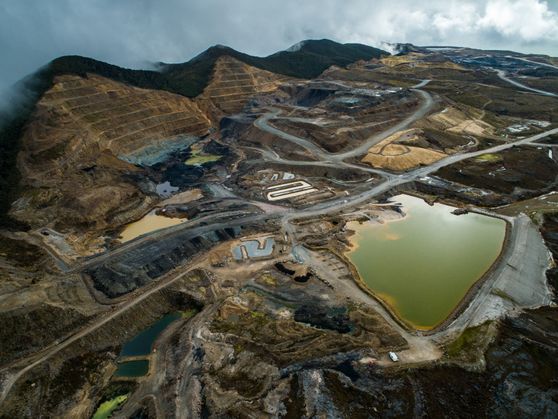 open cast coal mine with dug-out hillsides, roads, and pooling water